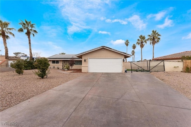 single story home featuring solar panels, fence, stucco siding, a garage, and a gate