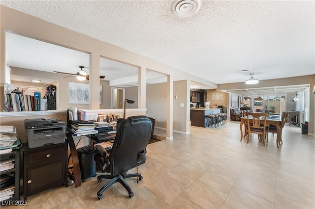 office featuring ceiling fan, baseboards, and a textured ceiling