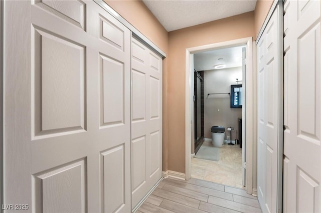 hallway with light wood-type flooring and baseboards