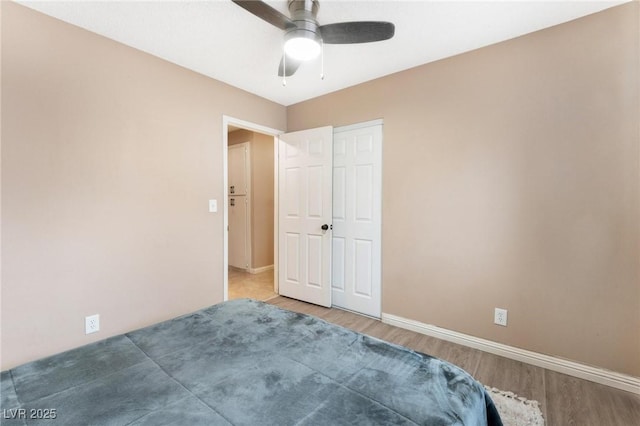 unfurnished bedroom with baseboards, wood finished floors, and a ceiling fan