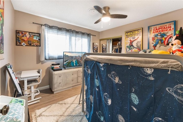 bedroom featuring a ceiling fan, baseboards, and wood finished floors