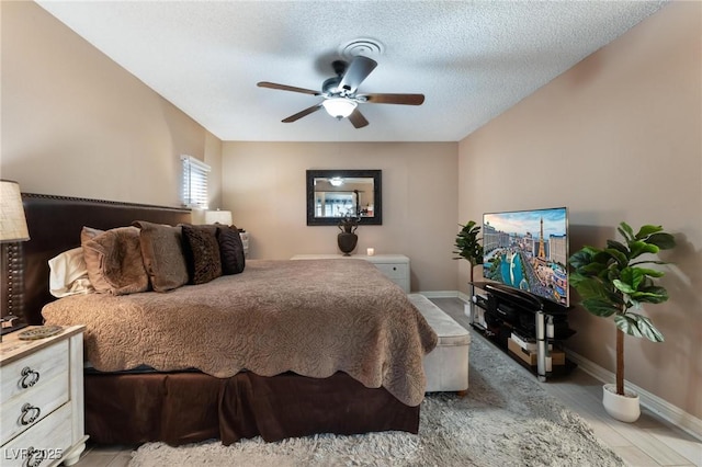 bedroom featuring visible vents, baseboards, a textured ceiling, and ceiling fan