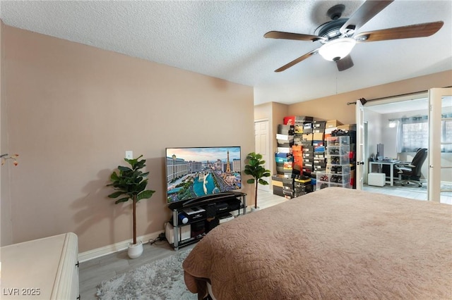 bedroom with ceiling fan, baseboards, and a textured ceiling