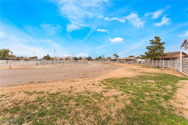 view of yard featuring an outdoor structure, a rural view, and an exterior structure