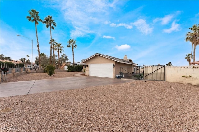 exterior space featuring a gate, concrete driveway, an attached garage, and fence