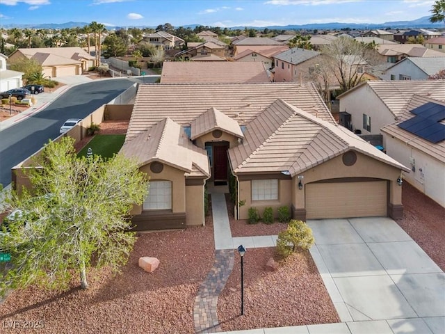 view of front of house with a tile roof, concrete driveway, and a residential view