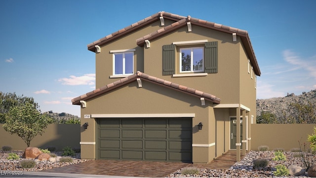 view of front of home with stucco siding, a tile roof, decorative driveway, fence, and an attached garage