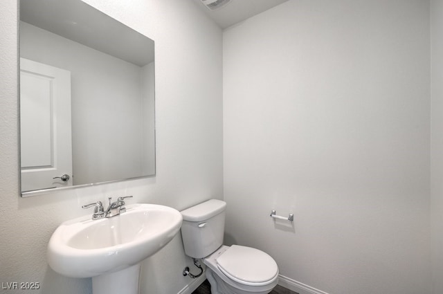 bathroom with a sink, visible vents, baseboards, and toilet