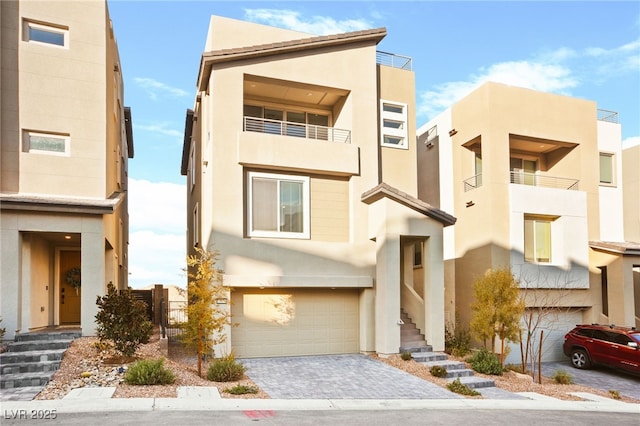 view of front of home featuring stairway, stucco siding, an attached garage, and decorative driveway