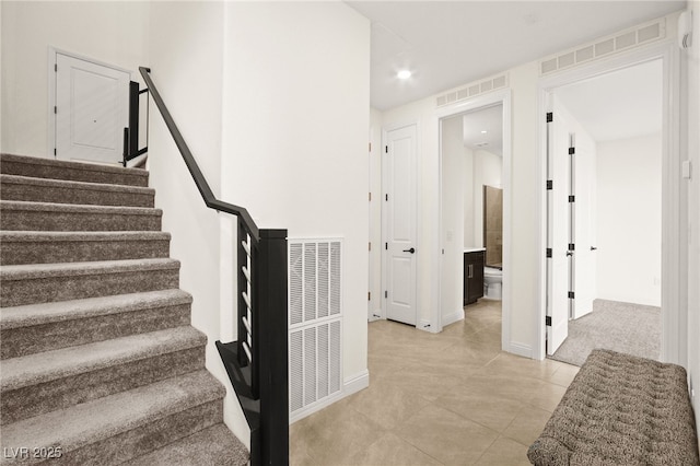 stairway featuring tile patterned flooring, baseboards, and visible vents