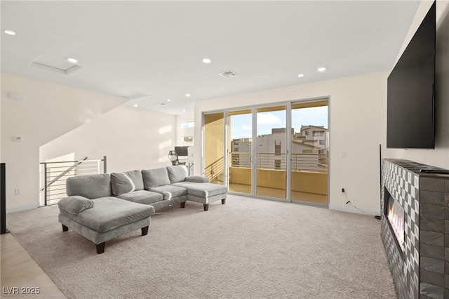 living area with visible vents, recessed lighting, baseboards, and a glass covered fireplace