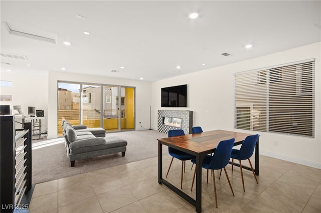 dining space featuring visible vents, recessed lighting, a fireplace, and light colored carpet