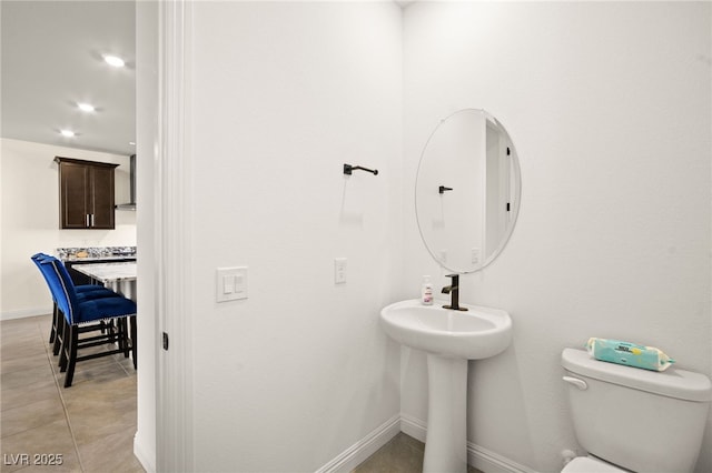 half bath with tile patterned floors, baseboards, toilet, and recessed lighting