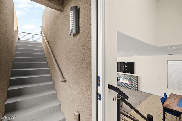 stairway with tile patterned floors, baseboards, and a tile fireplace