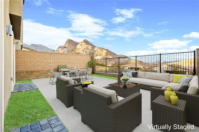 view of patio with outdoor dining space, a mountain view, an outdoor hangout area, and a fenced backyard