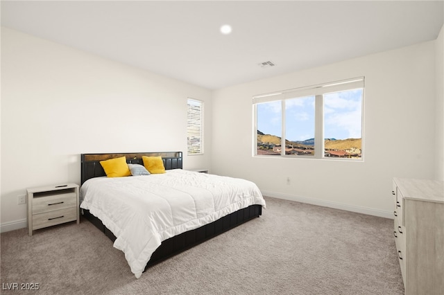 bedroom with light colored carpet, visible vents, and baseboards