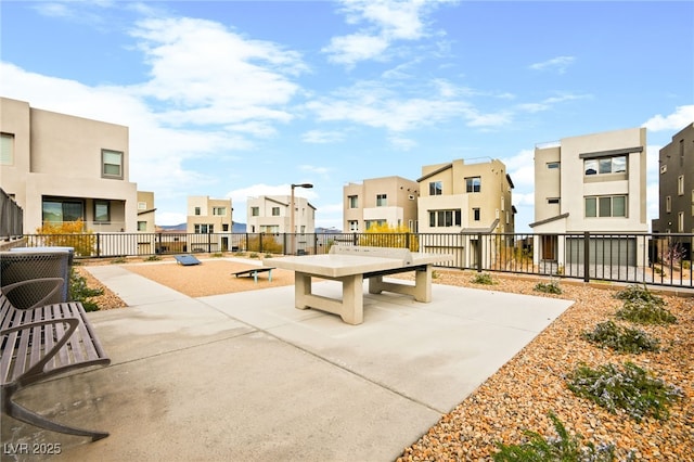 view of community with a patio, fence, and a residential view