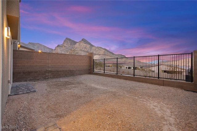 view of yard with a mountain view, a fenced backyard, and a patio area