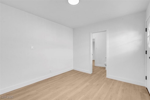 unfurnished room featuring baseboards and light wood finished floors