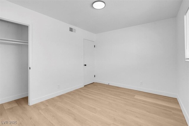 unfurnished bedroom with light wood finished floors, visible vents, and baseboards