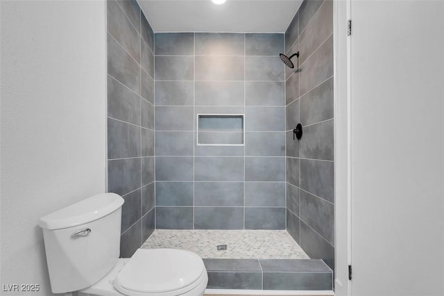 bathroom featuring toilet and a shower stall