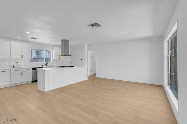 kitchen with visible vents, dishwasher, light countertops, light wood-style flooring, and island range hood