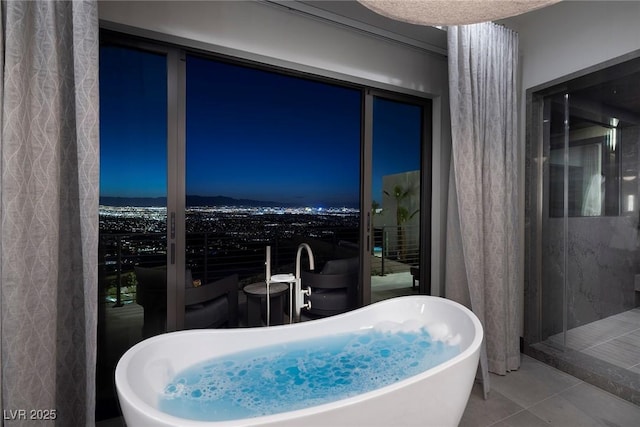 bathroom with tile patterned floors and a freestanding tub
