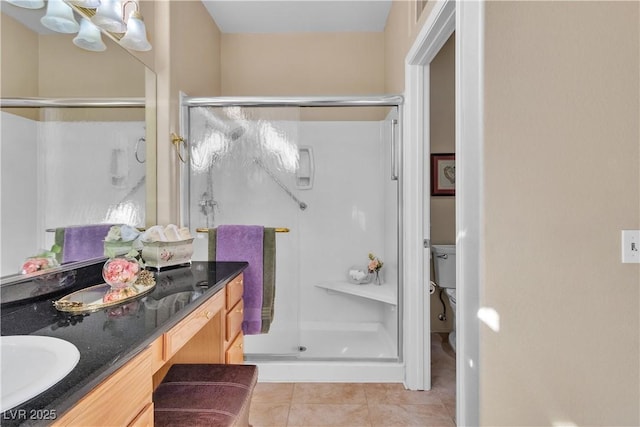 bathroom with double vanity, a stall shower, tile patterned floors, and a sink