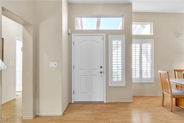 foyer featuring light wood-style floors and baseboards