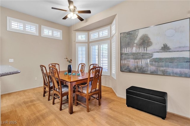 dining space featuring a ceiling fan, wood finished floors, and baseboards