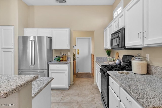 kitchen with black appliances, white cabinets, and light stone countertops