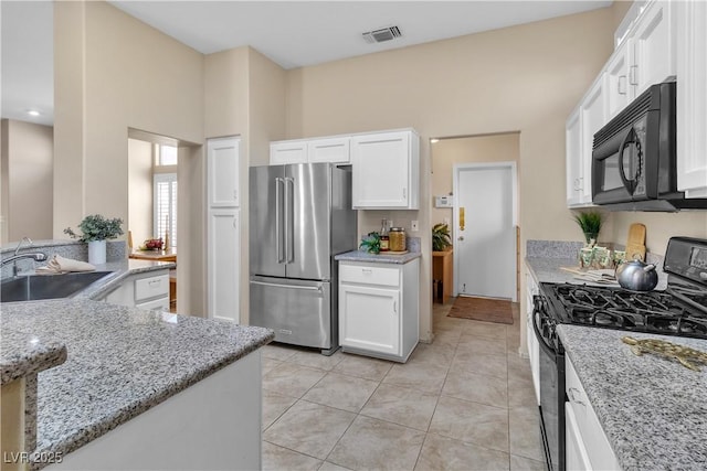 kitchen with light tile patterned floors, visible vents, a sink, black appliances, and white cabinets