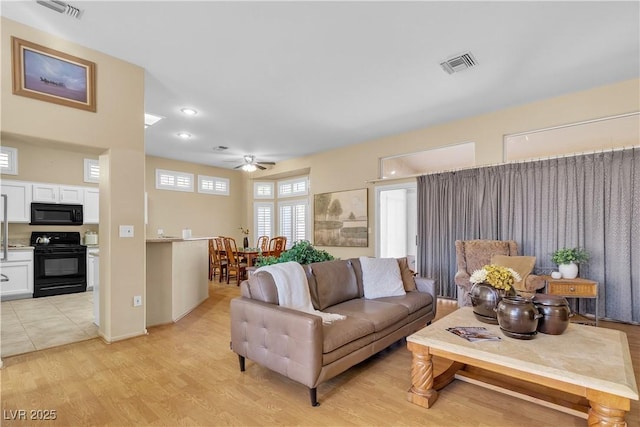 living area with visible vents, light wood-type flooring, and ceiling fan