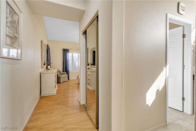 hallway with baseboards and light wood-style floors