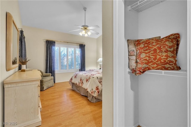 bedroom with vaulted ceiling, a ceiling fan, and light wood finished floors