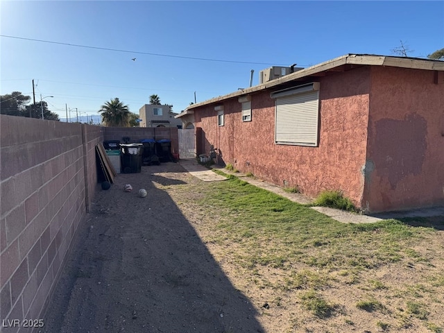 view of home's exterior with fence and stucco siding