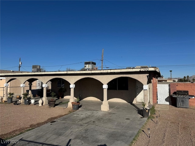 view of front of home featuring a patio area, stucco siding, cooling unit, and fence