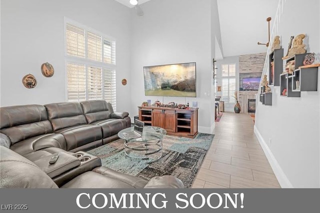 living room with a high ceiling and baseboards