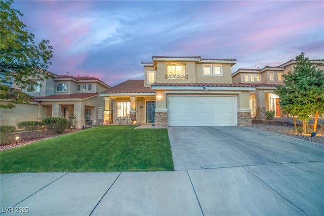 mediterranean / spanish home with a front lawn, concrete driveway, stone siding, and stucco siding