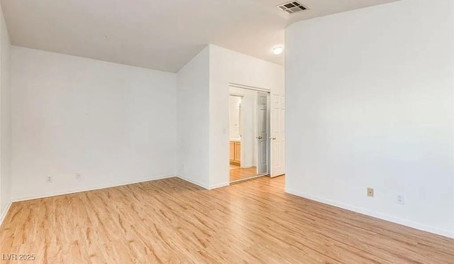 unfurnished room featuring visible vents, baseboards, and light wood-style floors