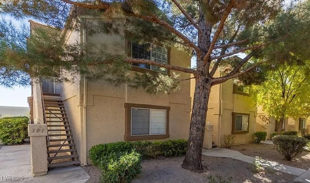 view of front of house with stucco siding and stairs