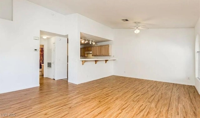 unfurnished living room featuring visible vents, light wood-style flooring, and a ceiling fan