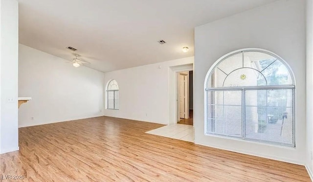 unfurnished living room featuring visible vents, wood finished floors, and a ceiling fan