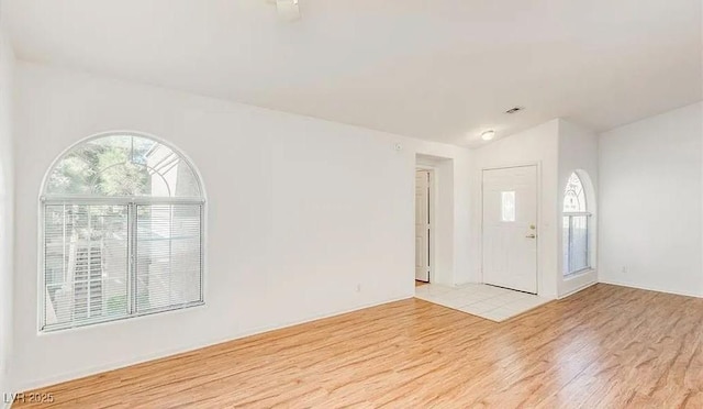 foyer entrance featuring lofted ceiling and light wood-style flooring