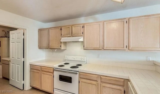 kitchen featuring white electric range oven, tile countertops, under cabinet range hood, and light brown cabinetry