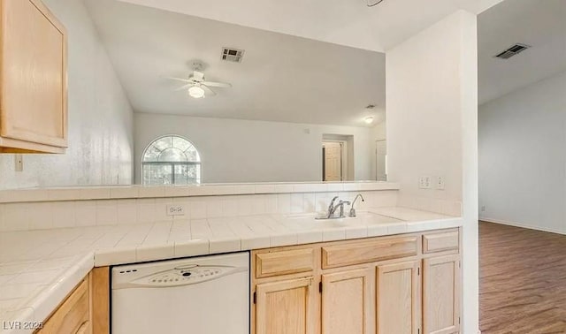 kitchen with light brown cabinetry, visible vents, a ceiling fan, and white dishwasher