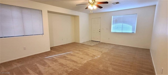 carpeted empty room featuring visible vents, baseboards, and a ceiling fan