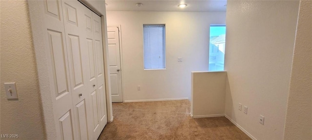 corridor featuring baseboards and carpet floors