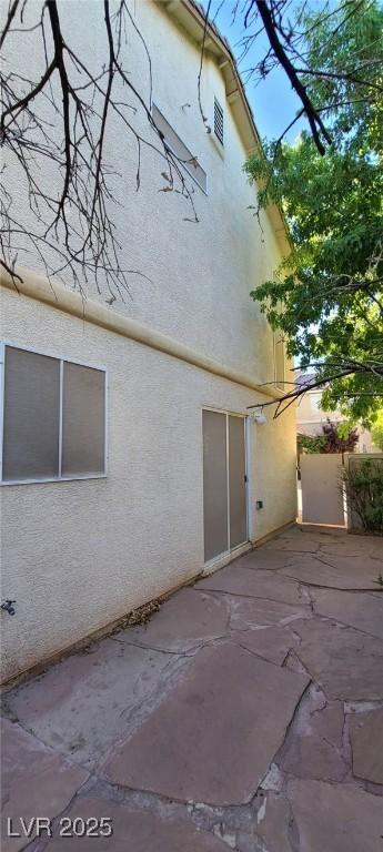 rear view of house featuring stucco siding and a patio