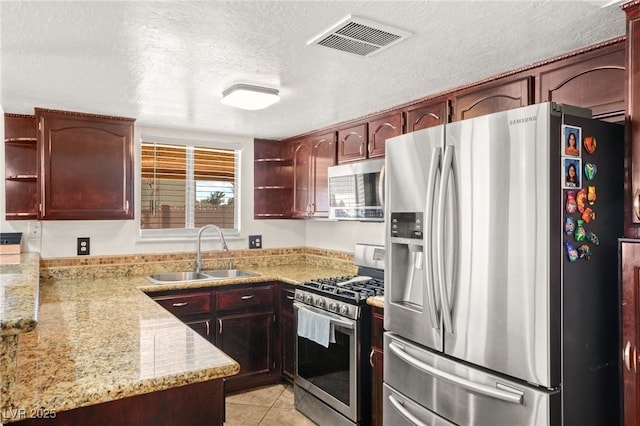 kitchen featuring visible vents, a sink, appliances with stainless steel finishes, light tile patterned flooring, and open shelves